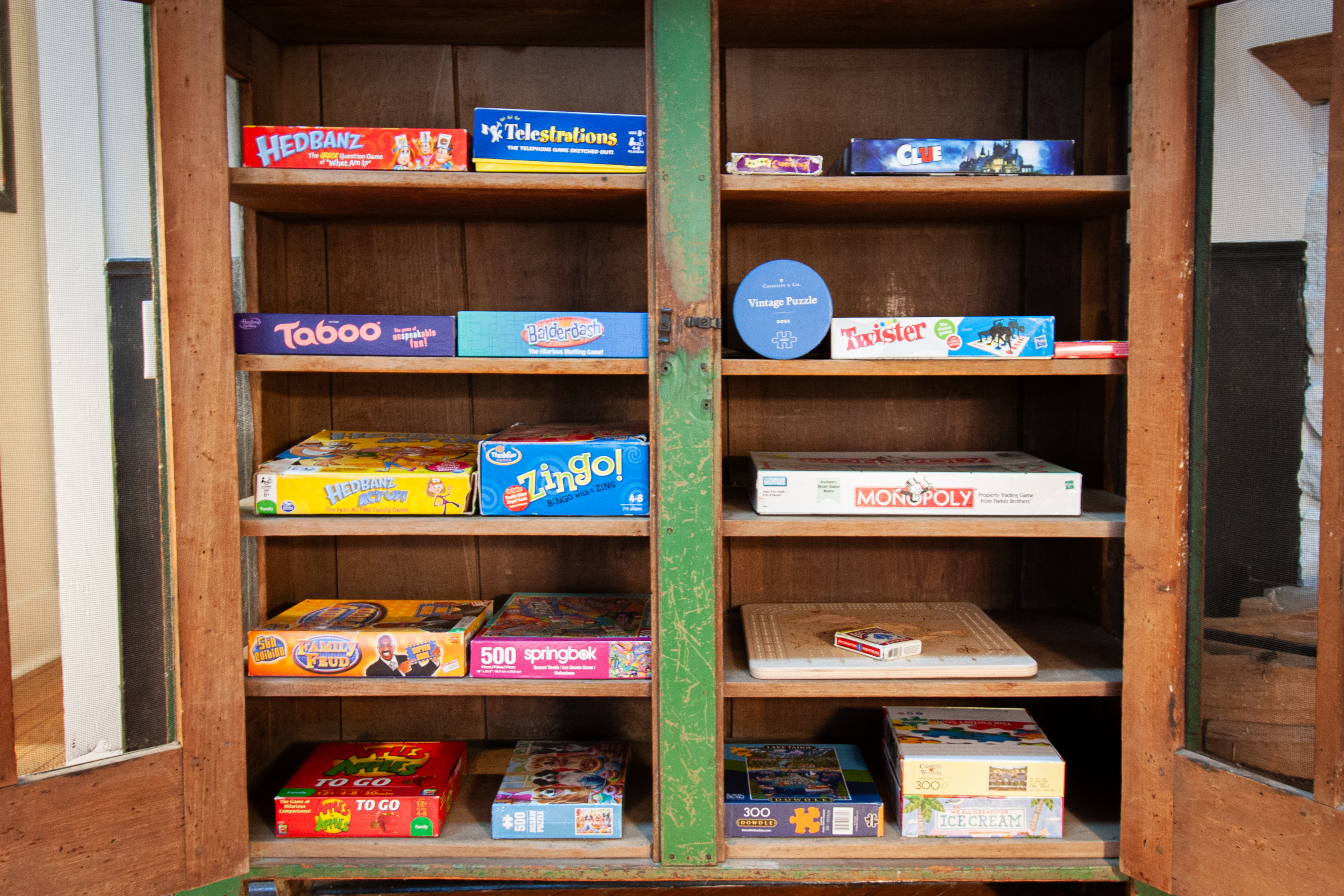 Shelf of board games including Monopoly and Clue
