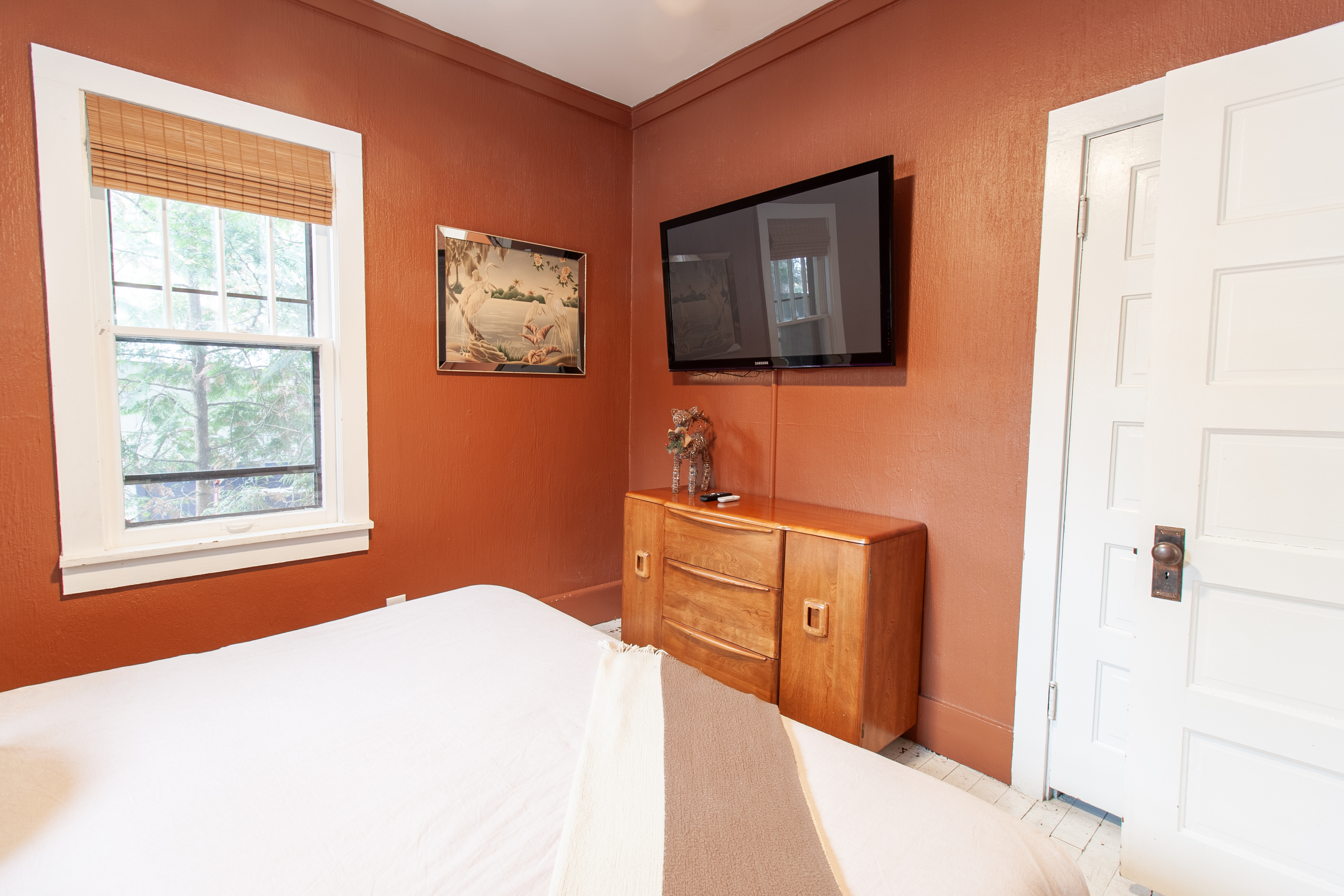 Bedroom with terracotta walls and TV