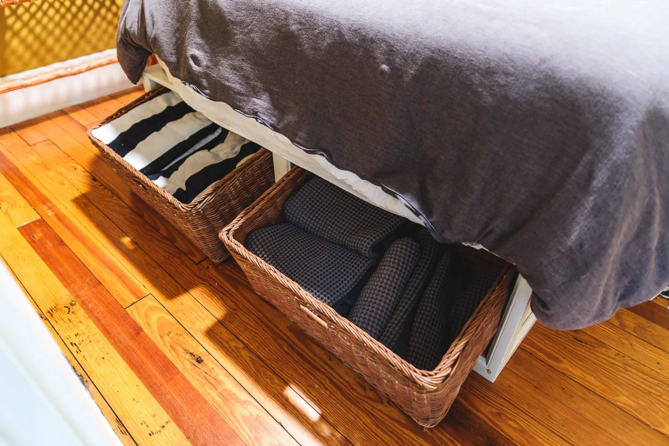 Under-bed storage baskets with extra linens and towels